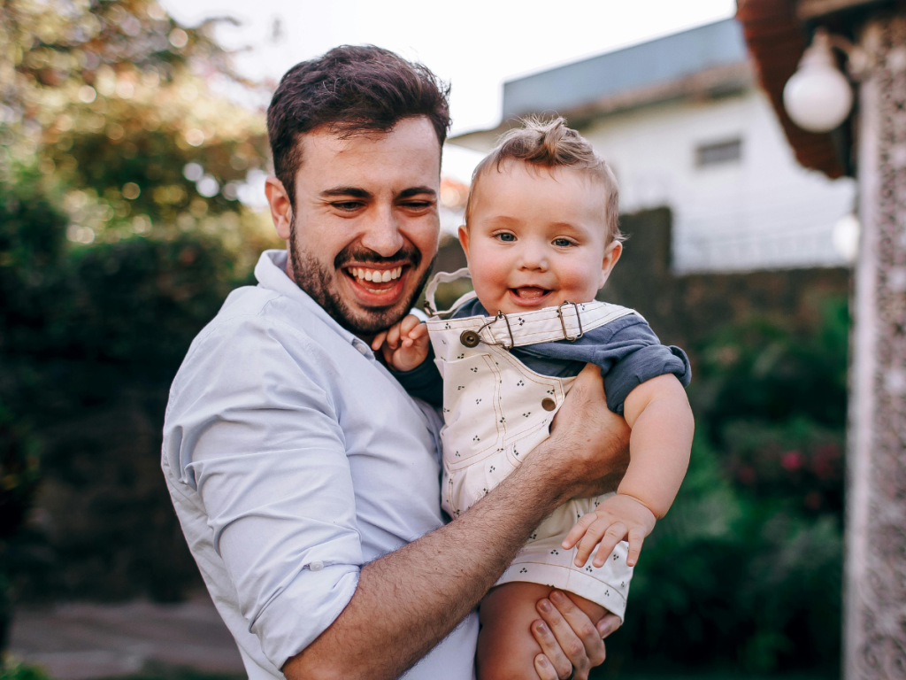 Parent holding child laughing together. Parent having questions about how to find the right ABA provider