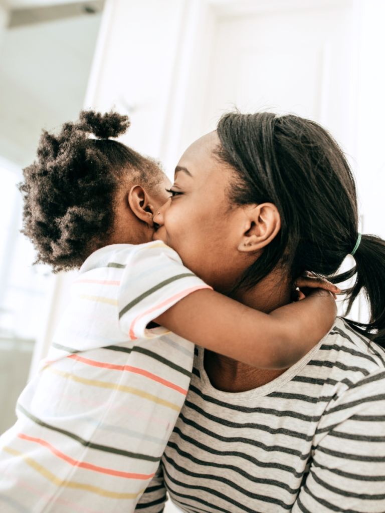 Child hugging parent, parent kissing child on the cheek. Parent has questions for potential ABA provider